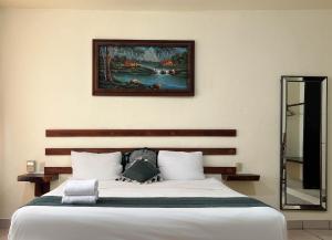 a bedroom with a bed with a painting on the wall at Casa Piedra Parada in Brisas de Zicatela +78 photos