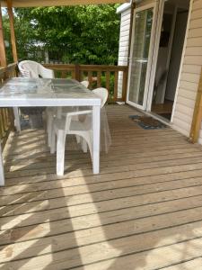 a white table and chairs on a deck at L'échapée verte in Litteau