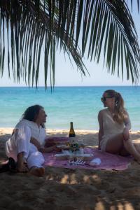 a man and a woman sitting on a blanket on the beach at Garden to Table Experience - Unit 101 in Rincon +20 photos