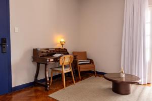 a room with a desk and a table with a chair at Altos de Colombo Guest House Boutique - Soft Opening in Rio de Janeiro