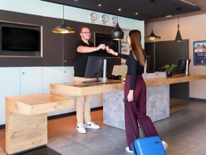 a man and a woman standing at a counter at ibis budget Bern Expo in Bern