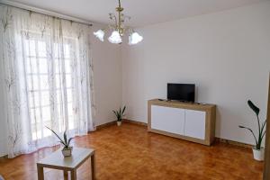a living room with a tv on a dresser and a table at Gli agrumi di Nonna Peppina - Appartamento Limoni in Mondragone