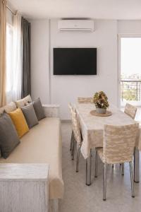 a living room with a couch and a table with chairs at Memories Studio in Neapoli Voion