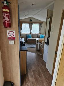 a kitchen and living room with a fire hydrant in a room at Manderley Caravan in Newquay Bay Resort +6 photos