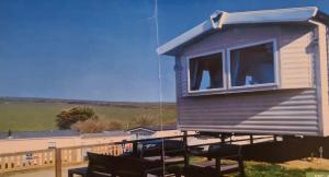 a tiny house sitting on top of a deck at Manderley Caravan in Newquay Bay Resort