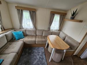 a living room with a couch and a table at Manderley Caravan in Newquay Bay Resort