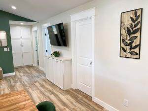 a living room with white walls and a flat screen tv at Charming Home Downtown Paso Robles in Paso Robles