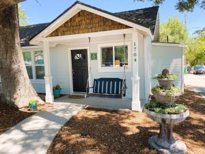 a white house with a porch with a black door at Charming Home Downtown Paso Robles in Paso Robles