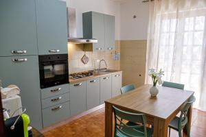 a kitchen with a table and a stove and a sink at Gli agrumi di Nonna Peppina - Appartamento Limoni in Mondragone