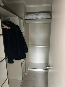 a small bathroom with a closet with white shelves at LUGAnO 301 in Temuco
