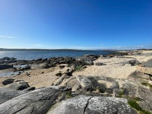 a beach with rocks and the ocean in the background at Red House in Galway