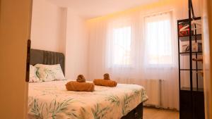 a bedroom with a bed with two stuffed animals on it at Enzo's Apartments Prishtina in Prishtinë