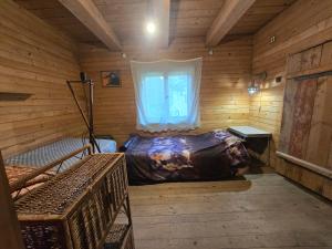 a bedroom in a log cabin with a bed and a window at Chata leśna u Górala in Stróża