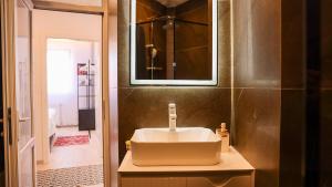 a bathroom with a white sink and a mirror at Enzo's Apartments Prishtina in Prishtinë +43 photos