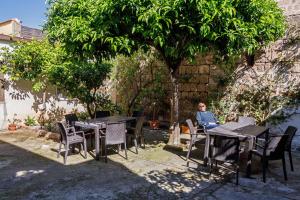 a man sitting at a table under a tree at Gli agrumi di Nonna Peppina - Appartamento Limoni in Mondragone
