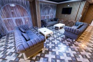 a living room with couches and a flat screen tv at Kars-i Si̇ri̇n Otel in Kars