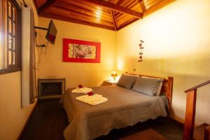 a bedroom with a bed with two towels on it at Pousada Recanto do Pico in Santo Antônio do Pinhal