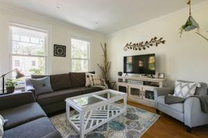 a living room with a couch and a tv at Iconic Modern Farmhouse in San Luis Obispo