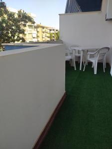 a table and chairs on a balcony with green grass at Domus de Silvi in Silvi Marina