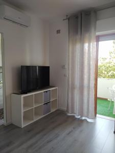 a living room with a flat screen tv on a cabinet at Domus de Silvi in Silvi Marina +4 photos