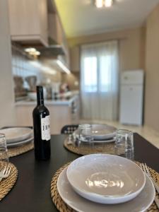 a bottle of wine sitting on a table with plates at Kaloula's home in Keramoto +6 photos