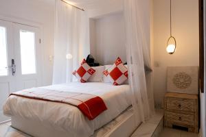 a white bedroom with a bed with red and white pillows at 18 On OniX - World Class in Four Ways +30 photos