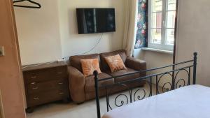 a living room with a couch and a television at Irie Vibes in Bourganeuf