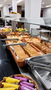 a buffet line with baskets of sandwiches and other foods at Basilica Palace Hotel in Aparecida