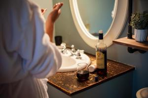a woman standing in front of a bathroom sink with a bottle of wine at Magnetic Hill Winery in Moncton +10 photos
