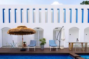 a pool with two chairs and a table and an umbrella at 18 On OniX - World Class in Four Ways