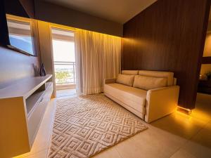 a living room with a couch and a window at Loft Prime Ribeirão Apogeo in Ribeirão Preto +54 photos