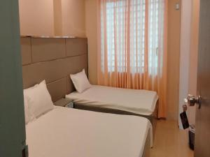 ein kleines Zimmer mit zwei Betten und einem Fenster in der Unterkunft Sylhet Hotel Grand Usman in Sylhet + 7 Fotos