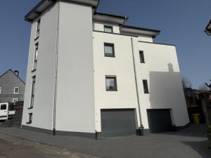 a large white building with a garage at Sauerland Apartment Deluxe in Olpe