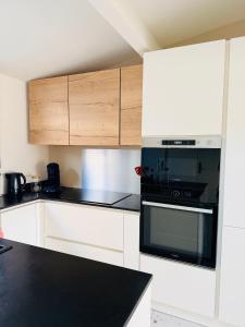 a kitchen with white cabinets and a black oven at SUPERBE maison, rénovée port de Carro -terrasse,calme & lumière in Martigues +20 photos