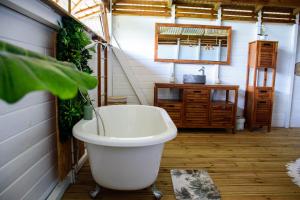 a bath tub sitting on the floor of a bathroom at Tootila in Sainte-Rose