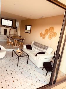 a living room with a white couch and a table at SUPERBE maison, rénovée port de Carro -terrasse,calme & lumière in Martigues