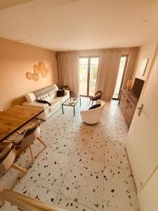 a living room with a couch and a table at SUPERBE maison, rénovée port de Carro -terrasse,calme & lumière in Martigues