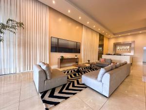 a living room with two couches and a television at Loft Prime Ribeirão Apogeo in Ribeirão Preto