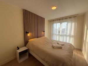 a bedroom with a white bed and a window at Le Cocon du Bord de Loire ! Appartement spacieux pour 6 personnes avec terrasse & parking in Nantes