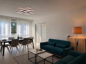 a living room with a green couch and a table at Le Cocon du Bord de Loire ! Appartement spacieux pour 6 personnes avec terrasse & parking in Nantes