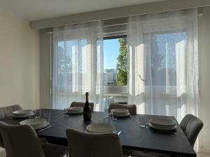 a dining room with a table and chairs and a window at Le Cocon du Bord de Loire ! Appartement spacieux pour 6 personnes avec terrasse & parking in Nantes +12 photos