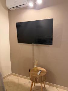 a flat screen tv on a wall with a table at Casa Dani - terrazza relax, parcheggio gratuito e comfort a due passi da Oneglia in Imperia