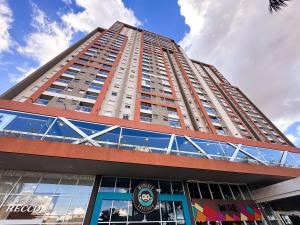 a tall building with a sign on the side of it at Loft Prime Ribeirão Apogeo in Ribeirão Preto