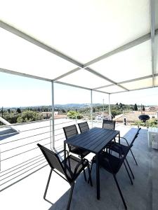 a black table and chairs on a balcony with an umbrella at Theo Two-Bedroom Apartment in Marathias +8 photos