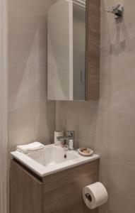 a bathroom with a white sink and a mirror at Lounetta Apartments 1 in Missolonghi