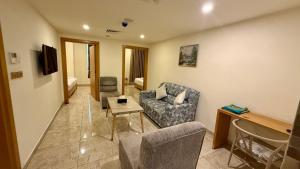 a living room with a couch and a table at Jawheret S Hotel Suite in Amman