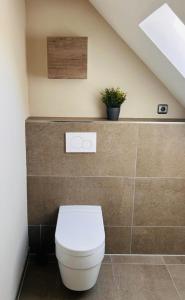 a bathroom with a toilet with a plant on the wall at Ferienwohnung Weitblick in Guxhagen