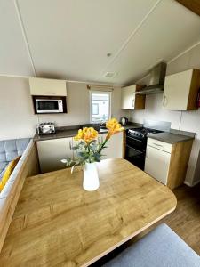 a kitchen with a table with a vase of yellow flowers at Atlantic 63 in Bude