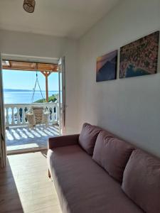ein Wohnzimmer mit Sofa und Meerblick in der Unterkunft Apartment Biondić in Starigrad