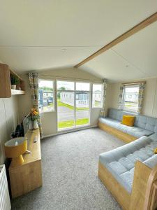a living room with a couch and a large window at Atlantic 63 in Bude